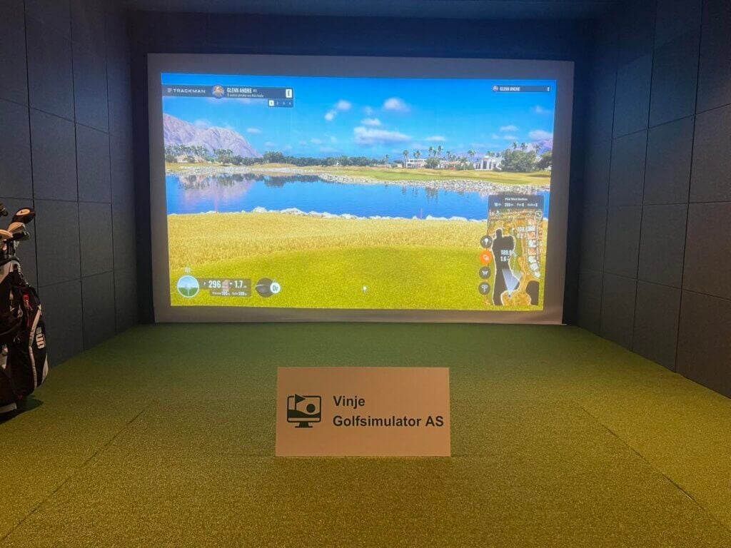 Golftrening med simulator hos Vinje Golfsimulator AS, realistisk landskap på stor skjerm, innendørs.
