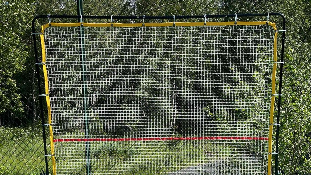 Målvegg i nett med grønn bakgrunn, perfekt for trening og forbedring av ballferdigheter.