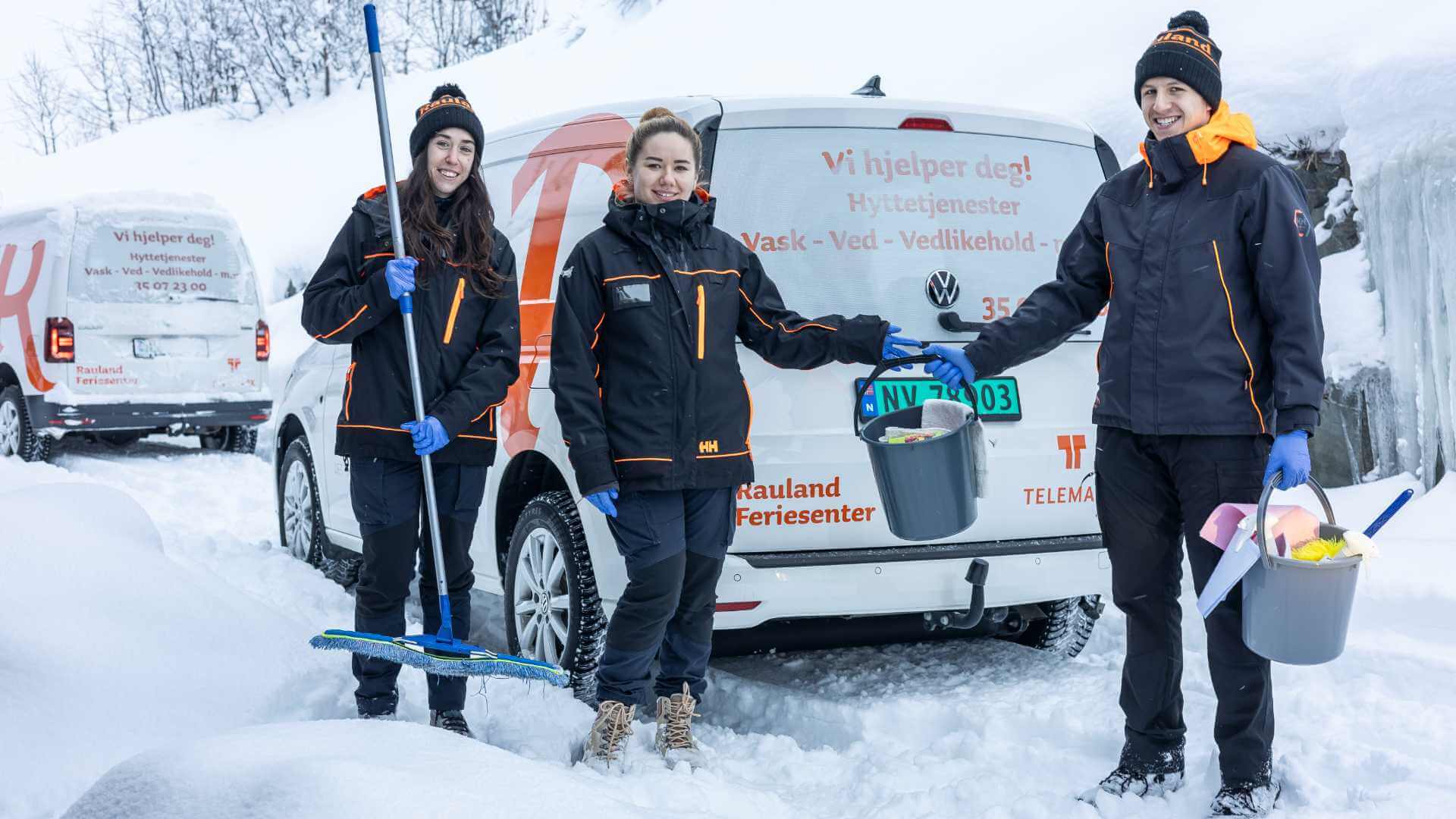 Tre mennesker i vinterklær med rengjøringsutstyr foran en varebil i snødekt landskap.