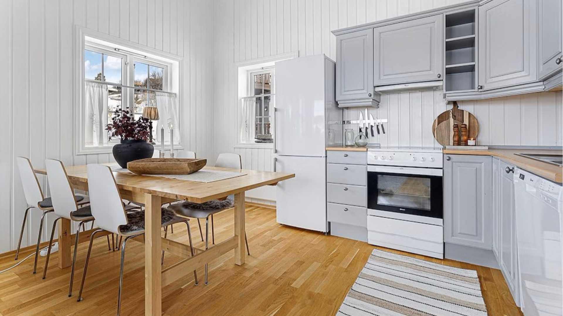 Moderne kjøkken med trebenk, spisebord og lyse vegger, perfekt for et koselig hjem.