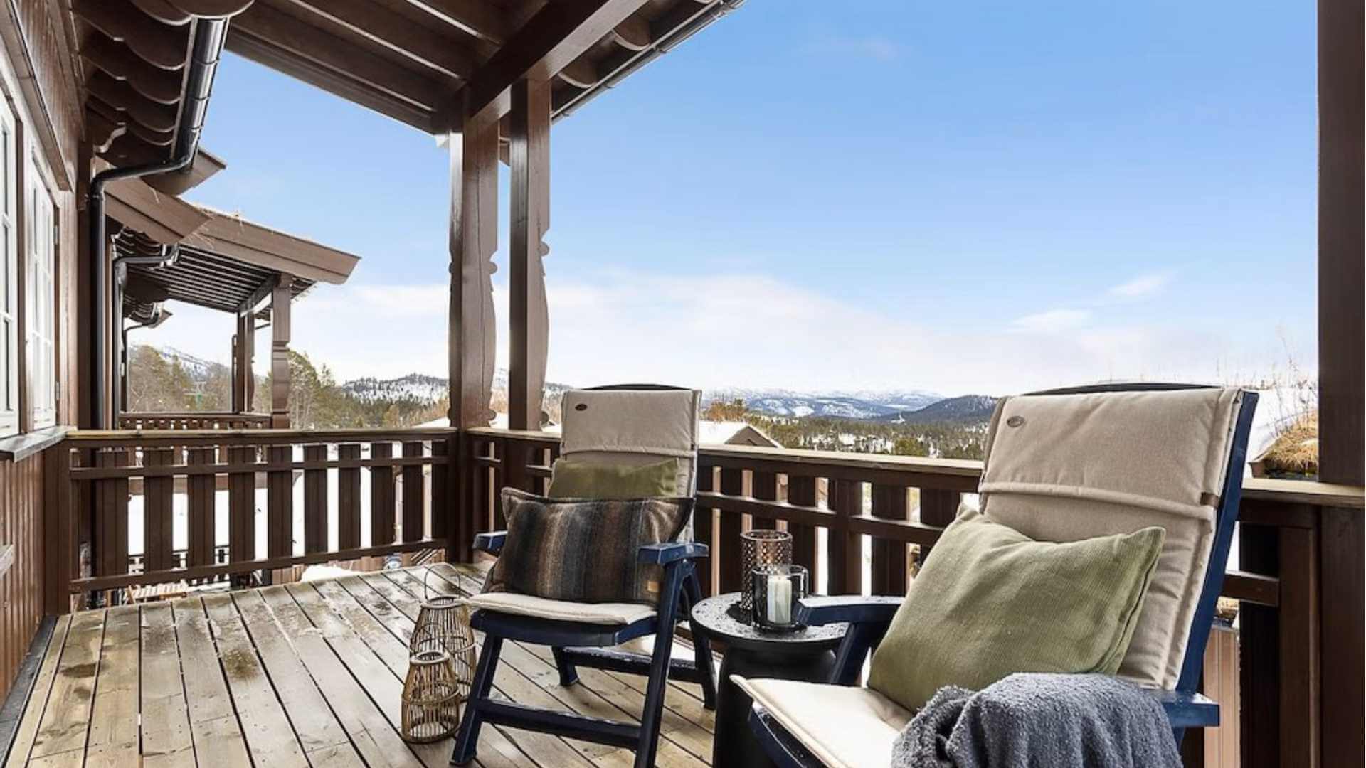 Koselig terrasse med utsikt, to stoler, puter og en solfylt himmel. Perfekt for avslapning i naturen.