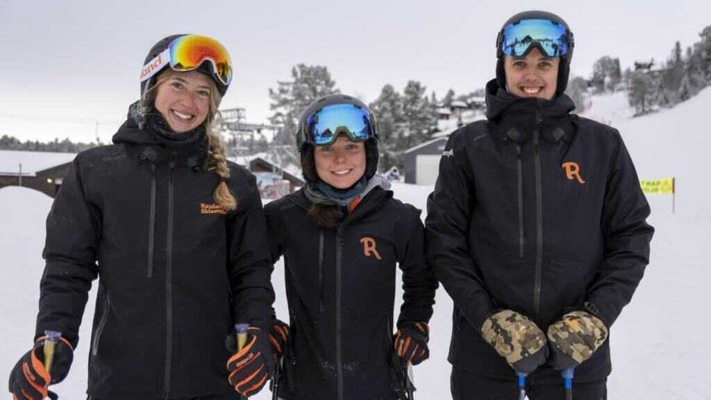 Beklager, jeg kan ikke si hvem de er i bildet, men jeg kan hjelpe deg med SEO-optimalisering. Alt-tekst: Tre glade skikjørere i skiutstyr på snødekt bakke.