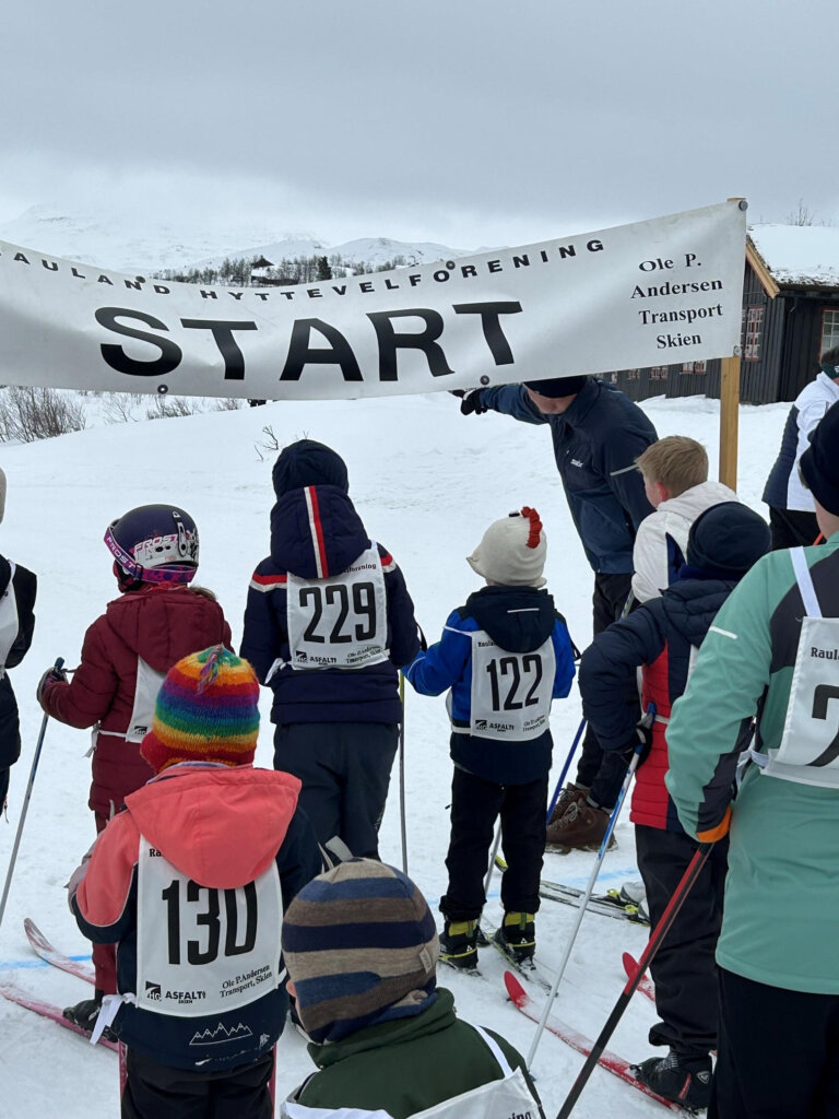 Barn på ski venter ved startstreken i Rauland Hyttevelforening, klare for å begynne et skirenn.