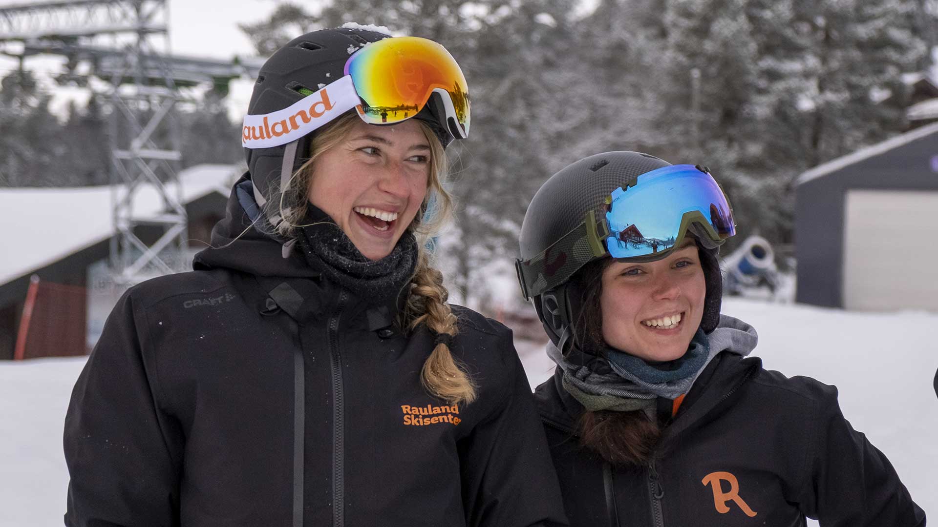 To kvinner i skiklær som smiler i snødekte fjell ved Rauland Skisenter.