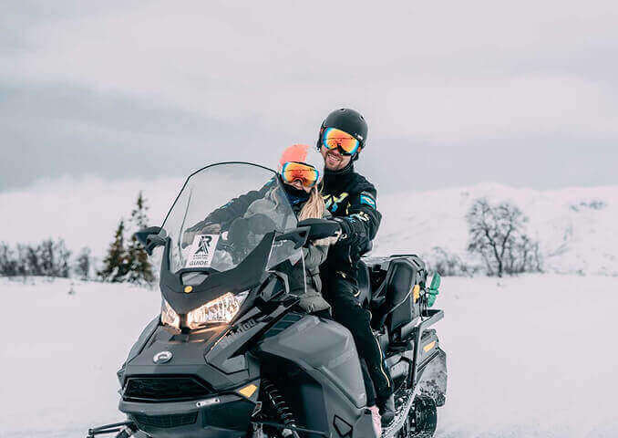 Kjapp snøscootertur med venner i snødekte fjell. Glede og eventyr venter!