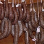 Hjemmelagde spekepølser i trehylle; autentisk norsk tradisjonell mat.
