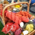 Fargerikt garn i kurver på et marked, klare for håndverk og strikking. Håndfarget ull for kreative prosjekter.