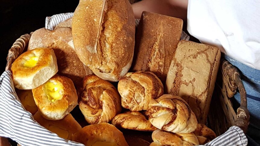 Friskbakte brød og boler i en kurv, perfekt for en koselig frokost eller kaféstund.