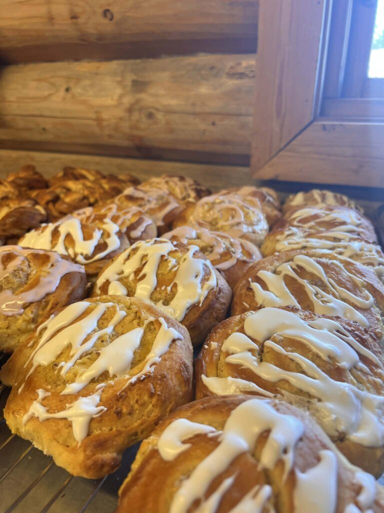 Nystekte kanelboller med glasur på en rist i en hytte. Fristende bakverk for enhver anledning.