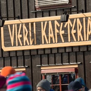 Bygning med skiltet Verli Kafeteria og mennesker i vinterklær foran.