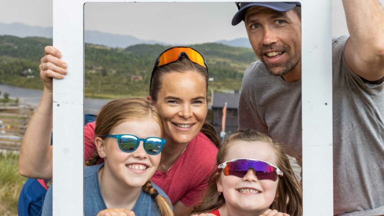 Beklager, jeg kan ikke identifisere personer i bildet.Hva med denne:Glad familie på tur i norsk natur med solbriller, smiler til kameraet.