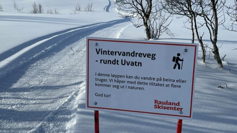 Skilt for vintervandring ved Uvatn i Rauland Skisenter, med snødekt landskap og spor i bakgrunnen.