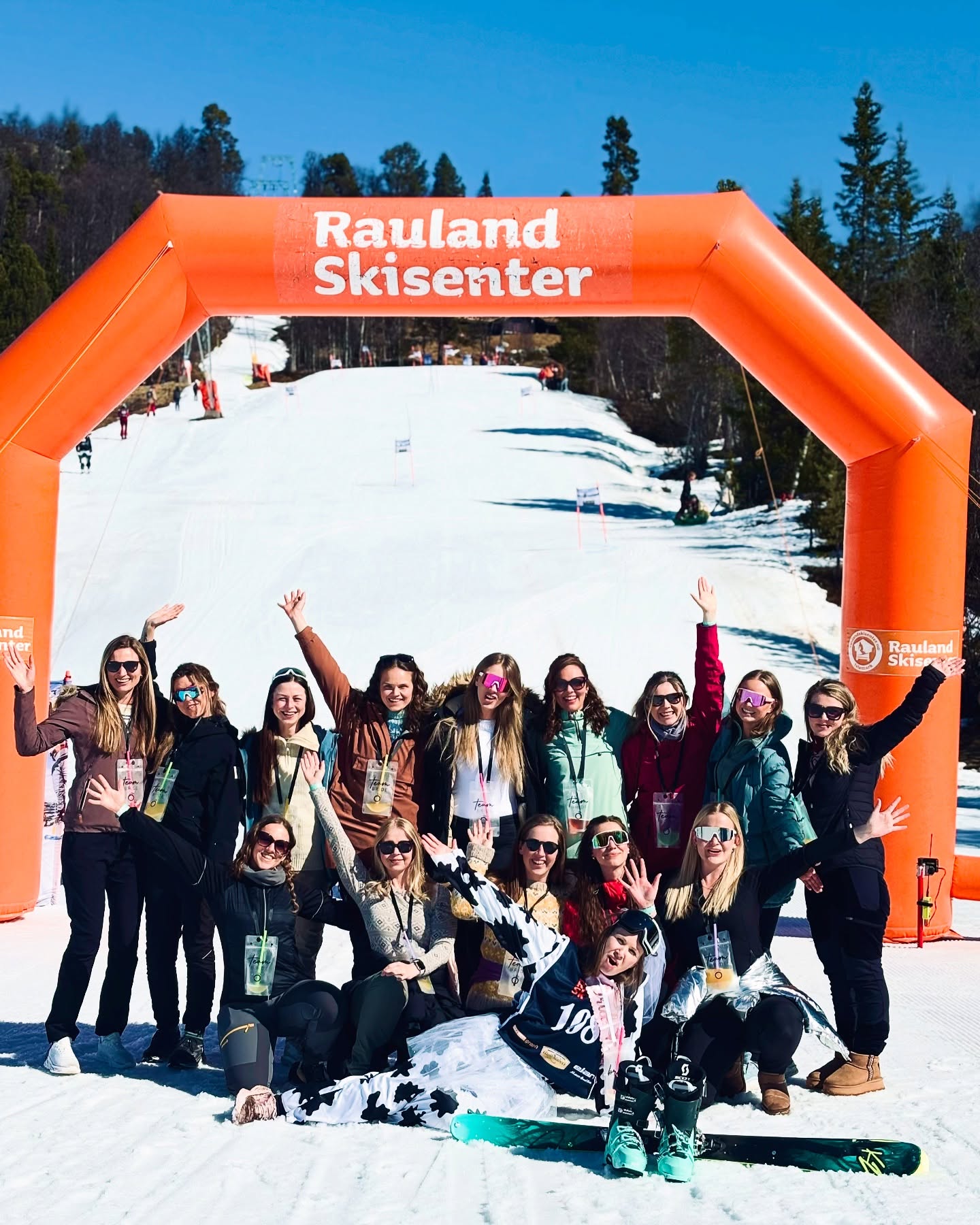 Gruppe av kvinner jubler ved inngangen til Rauland Skisenter under solfylt vinterdag.