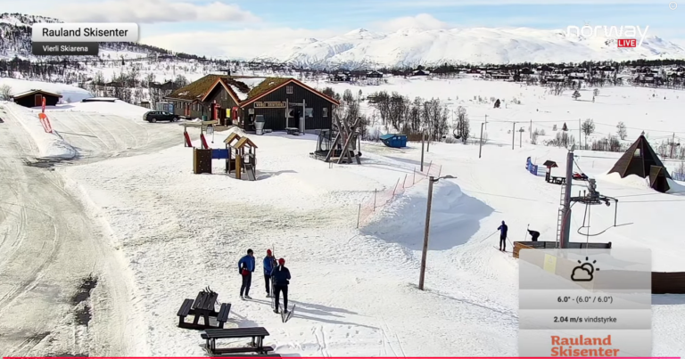 Bilde av Rauland Skisenter med snødekte bakker, skiheis og besøkende på en solfylt vinterdag.