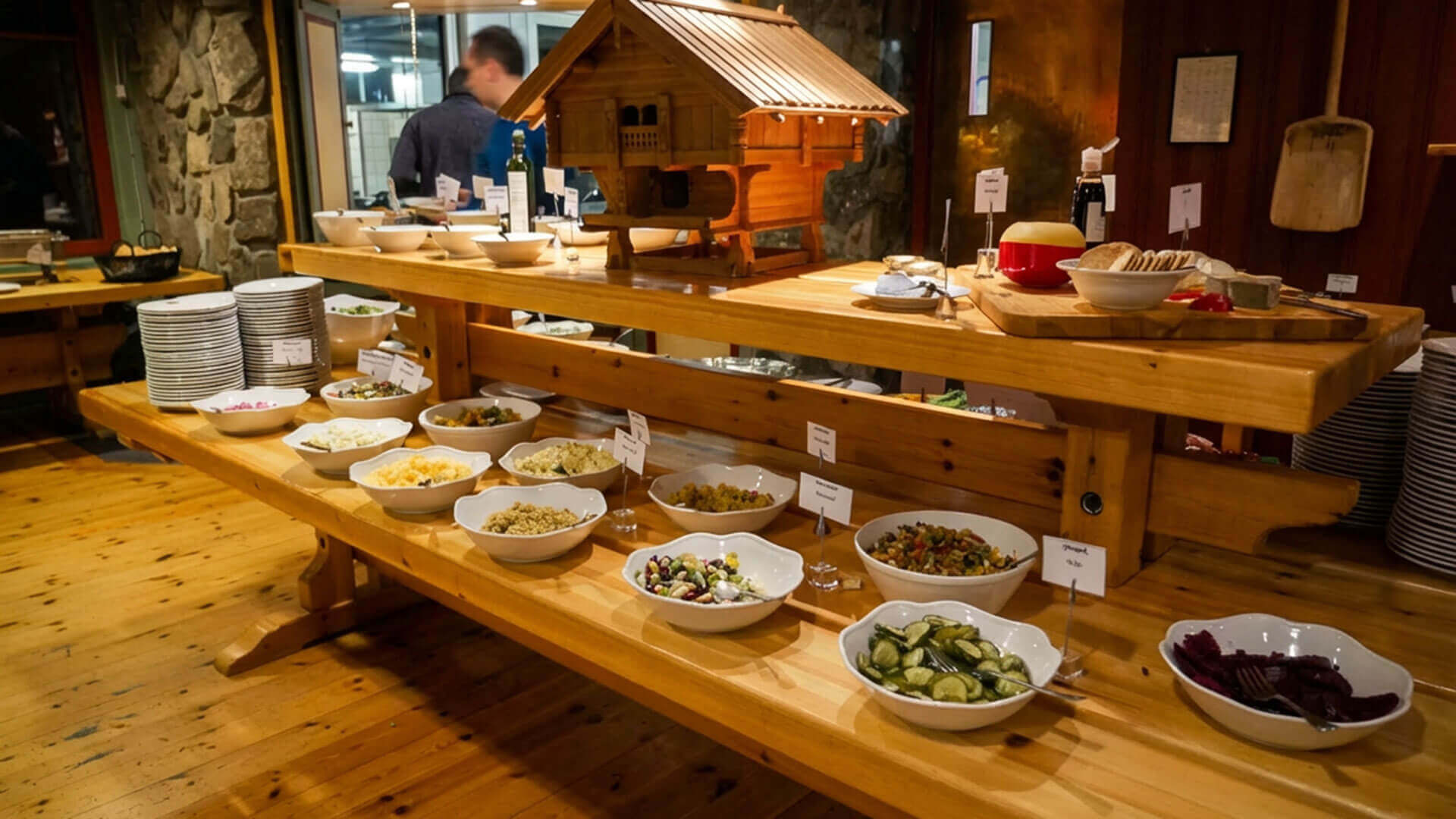 Buffé med ulike salater og tilbehør på trebord i norsk restaurant.