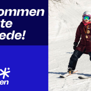 Barn nyter skiglede på Telenor Karusellen, iført hjelm og medalje, med teksten Velkommen til ekte skiglede!.