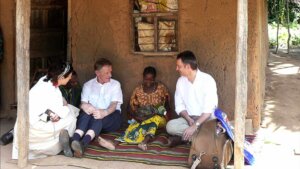 Møte mellom mennesker i tradisjonell setting, samtaler på en teppe i en landsby.