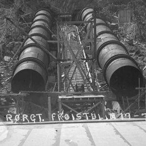 Konstruksjon av rørledninger i en gruve med skinner og stålrammer, tatt i juli 1926.