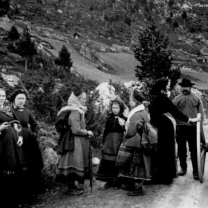 Kvinner og menn i tradisjonelle klær står ved en vei i Telemark, Norge, rundt 1884. Historisk sort-hvitt bilde.
